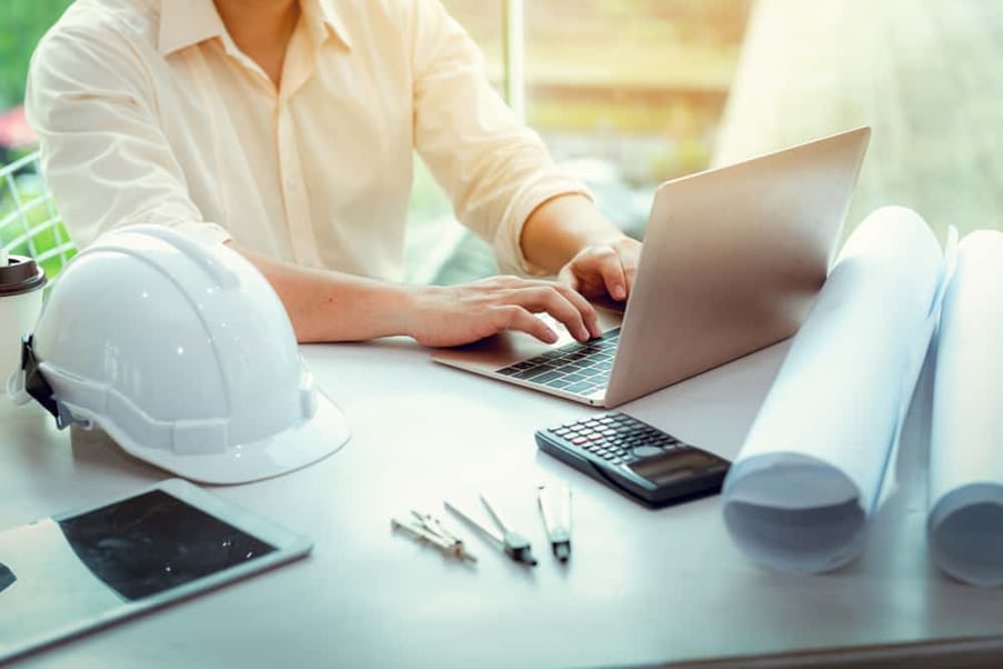 Worker using a laptop to research home improvement financing for contractors