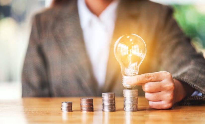 Coins and a lightbulb representing innovations in finance.