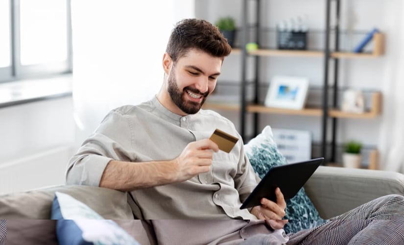 Man making a purchase on his tablet using his credit card.