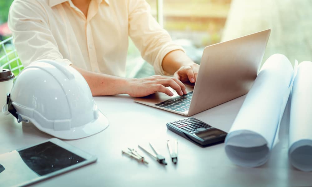 Worker using a laptop to research home improvement financing for contractors