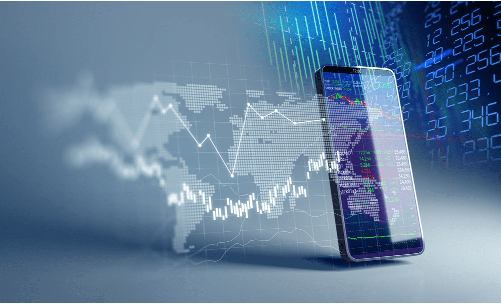 Fintech trends represented by a graphic laid over an iPhone with charts in the background.