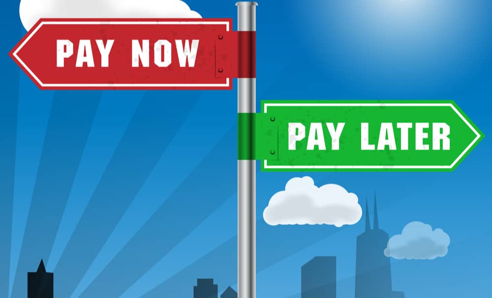 A red street sign reading buy now and a green street sign reading pay later signifying buy now pay later instant approvals